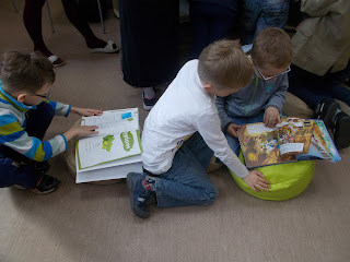 Dzieci czytają książki z zainteresowaniem w bibliotece na Bocianowie w Bydoszczy