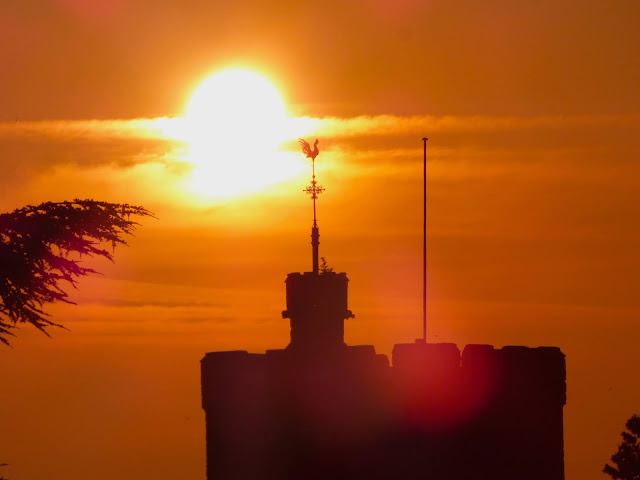 Sunrise at Tonbridge Castle - silhouette of Tonbridge Parish Church against an orange sky.