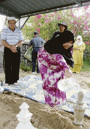 Ashraf Aleesha's parents doing the final rites after the burial