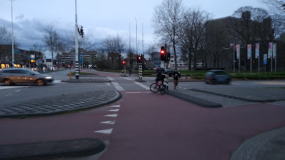 A large protected cross roads with an orbital cycle track and parallel pedestrian and cycle crossings.