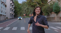 happy woman running down the middle of a road