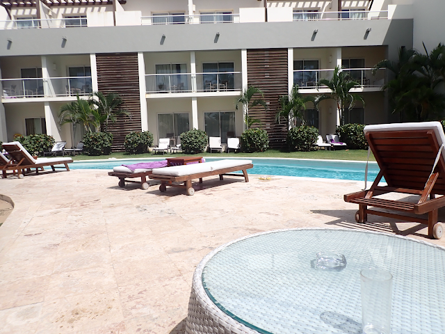 Many sun loungers overlook a swimming pool,, and hotel room balconies