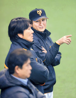 打撃練習中にケージの後方で松井臨時コーチ（左）と選手の動きをチェックする高橋監督