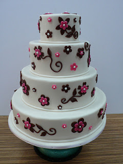 4 tier white wedding cake with black and pink flowers