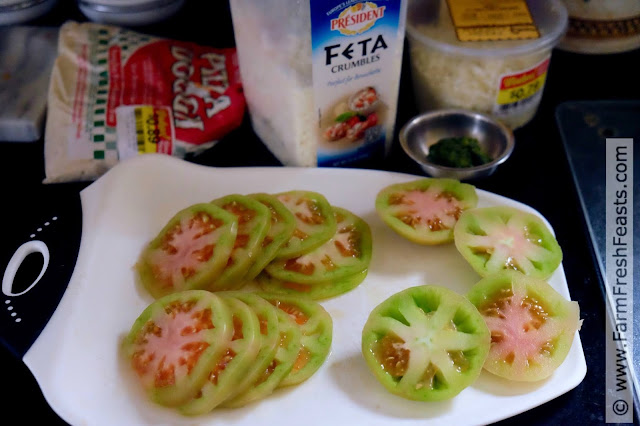 the ingredients for making green tomato pizza with pesto and feta