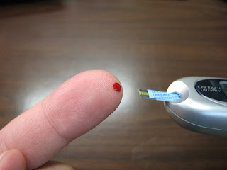 Test strip and blood on finger tip