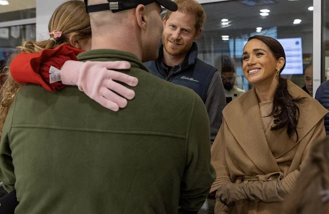 Meghan Markle wore a green Oseph off shoulder gown by Greta Constantine, and a camel baby alpaca cape by Sentaler