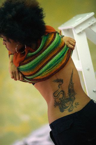 Black female with dragon phoenix tattoo on her lower back.