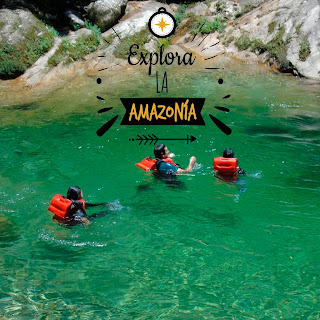 Turistas extranjeros disfrutan nadando en las aguas cristalinas y refrescantes de la Laguna Azul, descubriendo la belleza natural de este paraíso tropical en Tena, Ecuador.