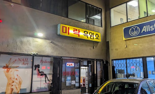 Restaurant facade tucked into back corner of small plaza