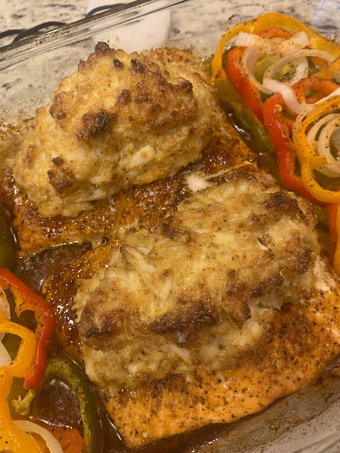 Stuffed Salmon in a glass dish with crabmeat and onions peppers sitting on the countertop.