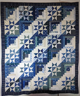 This scrap quilt alternates Log Cabin and split Ohio Star blocks to create a straight furrow design diagonally across the surface.