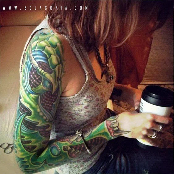 Chica con tatuaje de estilo biomecanico verde
