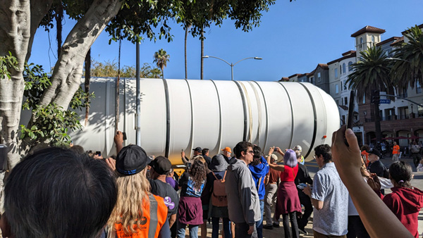 The crowd of onlookers continues to watch as one of Endeavour's two solid rocket motors enters the premises at Exposition Park in Los Angeles...on October 11, 2023.