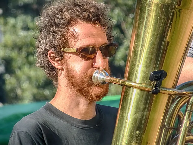 Retrato músico pelirrojo tocando la tuba.