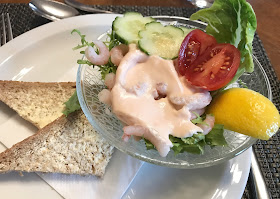 prawn cocktail starer in glass bowl with two slices brown bread and butter