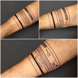 Tatuaje objetivo fotográfico alrededor del brazo