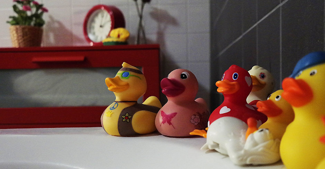 A collection of rubber ducks on the side of a bath