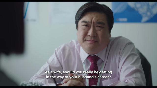 Większy mężczyzna siedzący w biurze, tekst "As a wife, shoud you really be getting in the way of your husband's career" (Czy jako żona powinnać przeszkadzać mężowi w rozwijaniu kariery?)