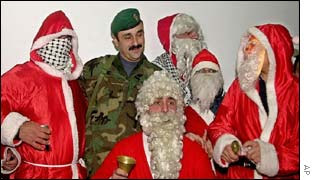 Palestinian men, dressed as Santa Claus, surround a guard