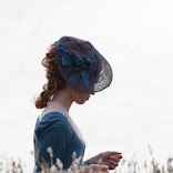 Elizabeth Poldark in the meadow in a blue dress and blue side hat