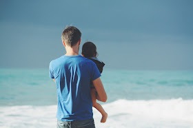 father and daughter looking out at the ocean