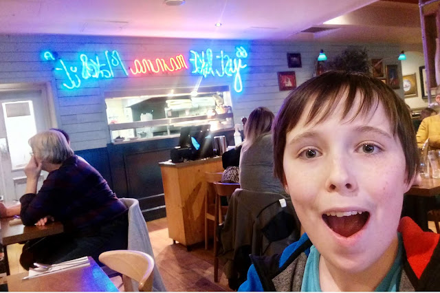 A boy in a restaurant looking very happy