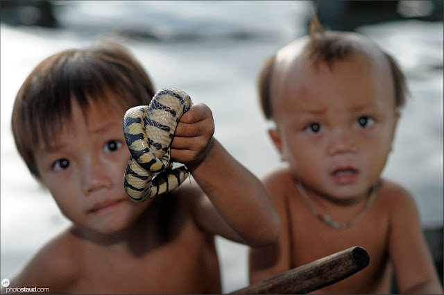Little boys holding snakes, Tonle Sap Lake, Cambodia