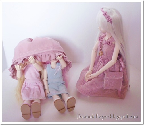 Two dolls hiding underneath some clothes.