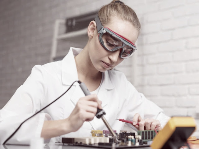 A girl soldering with an arduino,blonde woman