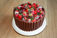 Chocolate and raspberry gateau topped with raspberries and chocolate-dipped strawberries