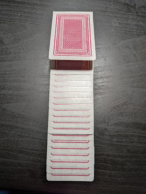 Photo of playing cards assembled into a card that looks like they are stacked on each other with a little bit of offset on each card