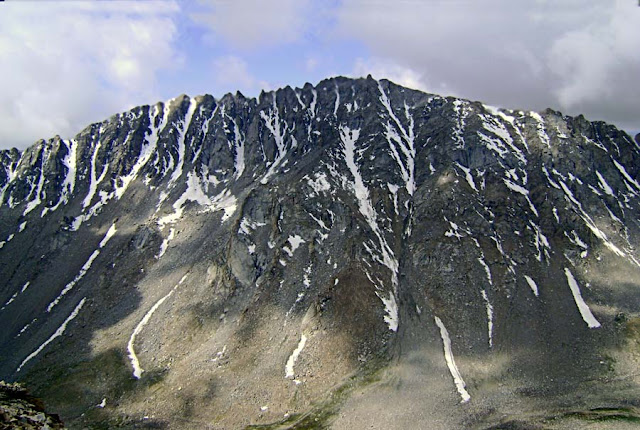 snow in stripes coming down a mountain