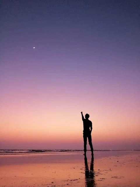 A person standing alone on a beach under the full moon, reflecting deep emotions during a full moon night.