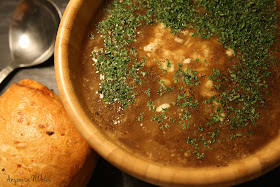 A bowl of French onion soup with a cheese roll.