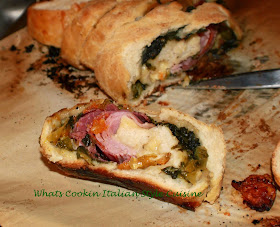 this is a pizza dough with a filling of Antipasto ingredients. there are tomatoes, escarole, salami, mortadella, hot capicola and imported Italian cheeses in this roll baked and this is sliced to show what the filling looks like inside