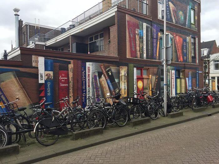 Dutch Artists Paint An Enormous Bookcase On An Apartment Building That Features Residents’ Favorite Books