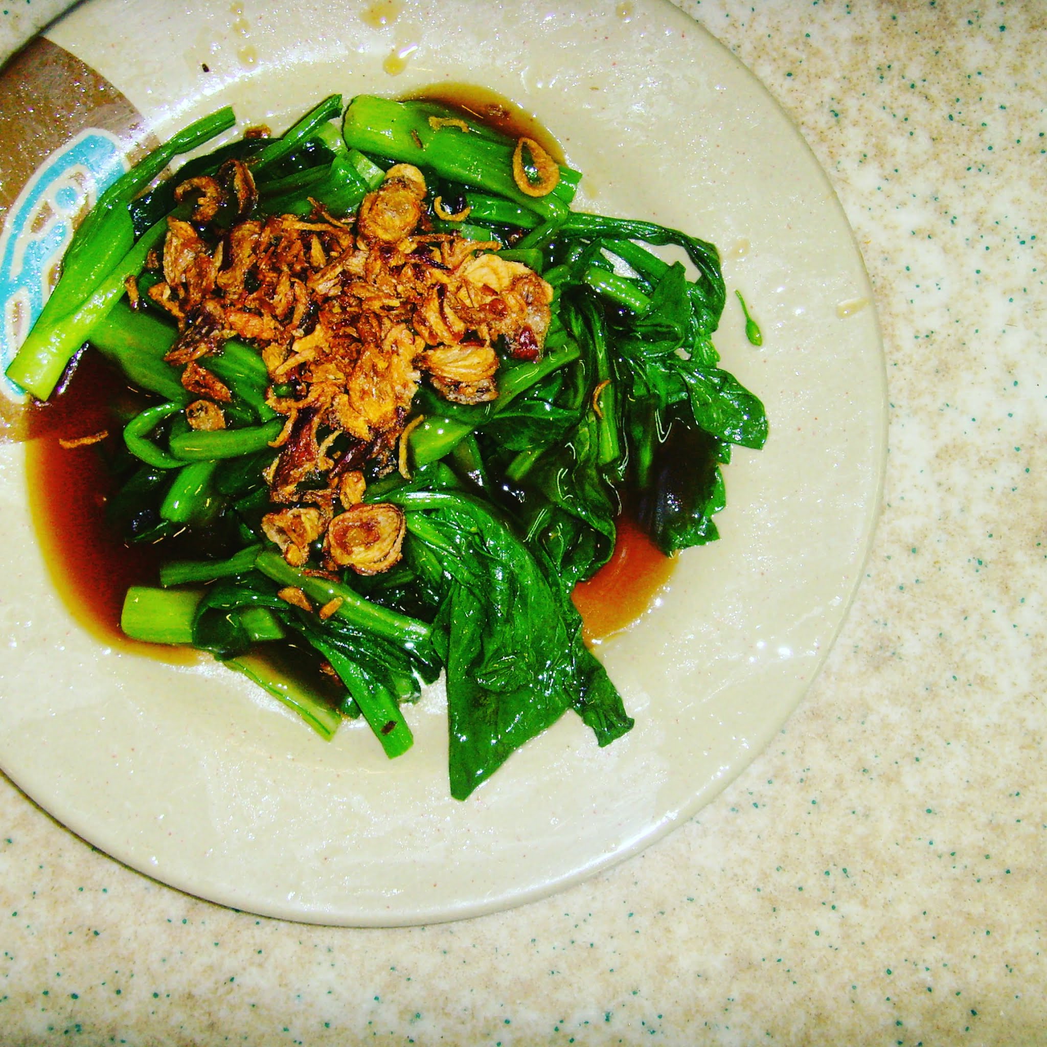 chinese broccoli and soy on brown plate in singapore's maxwell food centre, a must visit during 48 hours in singapore