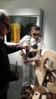 Alumnos reconociendo una rueca de madera