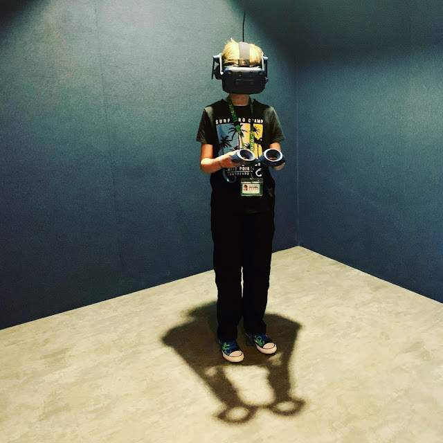 madmumof7's youngest son wearing headset and holding controllers at DNA VR