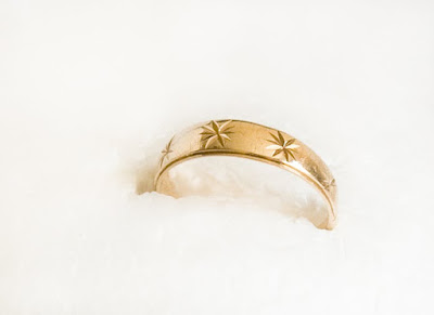 a gold wedding band engraved with stars