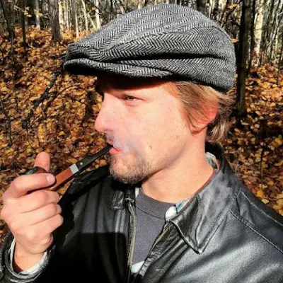 Side view handsome man looking pipe wearing black leather jacket on the newsboy cap