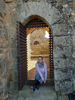 mulher sentada numa porta medieval