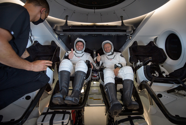 NASA astronauts Bob Behnken and Doug Hurley give thumbs-up before they egress from SpaceX's Dragon Endeavour capsule...after successfully completing the historic Demo-2 mission on August 2, 2020.
