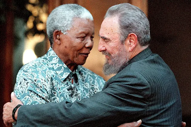 Image Attribute: Former South African President Nelson Mandela (L) hugs Cuba's President Fidel Castro during a visit to Mandela's home in Houghton, Johannesburg in this September 2, 2001 file photo.  REUTERS/Chris Kotze/File Photo
