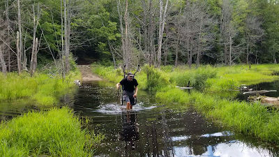 Sean Morton hiking flooded pathway.