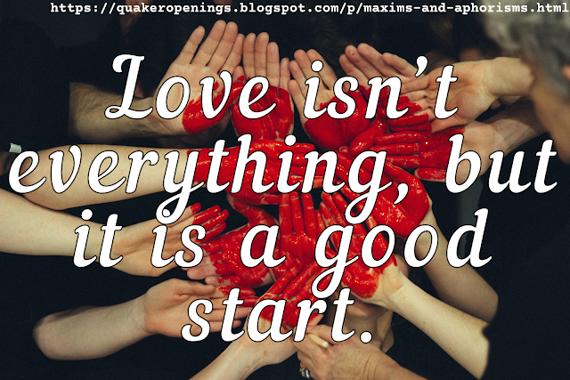 Photograph shows lots of people holding their hands flat, palms towards the camera, alongside one another, to form a nearly solid area of palms. On this area is drawn a heart in glossy red pigment. Text overlay reads "Love isn't everything, but it is a good start."