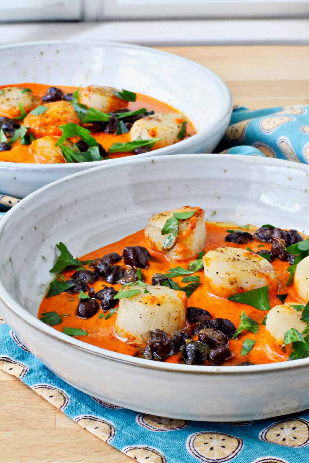 Pan-Seared Scallops with Black Beans and Red Pepper Sauce in white bowls.