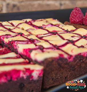 Cut squares of Raspberry Cheesecake Brownies, ready to be served and enjoyed.