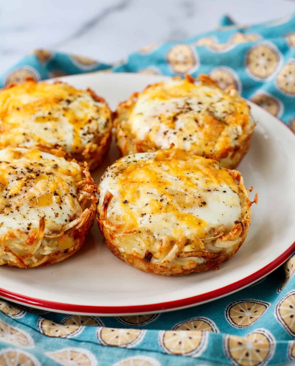 Four Baked Eggs in Hash Brown Potato Nests on a plate.